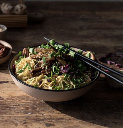Miso noodles with egg plants and shiitake in bowl on table