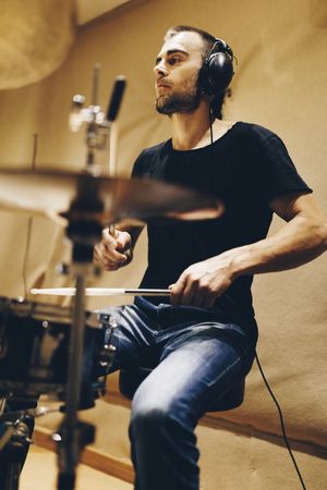 Man with headphones playing on drums