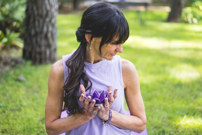 woman holding holding a purple glass lotus. Yoga and meditation concept.
