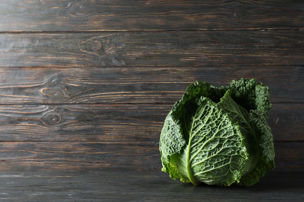 Fresh cabbage on wooden background, space for text