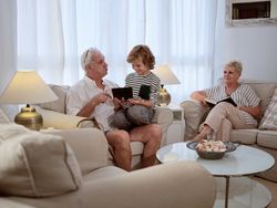Boy browsing tablet with grandfather on couch
