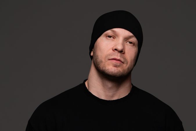 Man in beanie and sweatshirt, serious expression