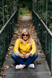 Happy female traveler taking selfie on suspension bridge in summer