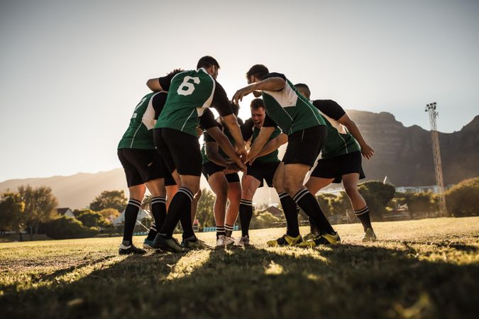 Rugby team putting their hands together after victory