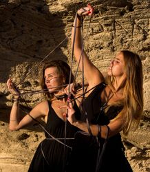 Women with thread posing near stones