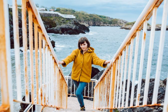 Woman standing on steps near sea