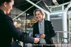 Smiling male traveler doing digital check in at airport terminal 413Pj0