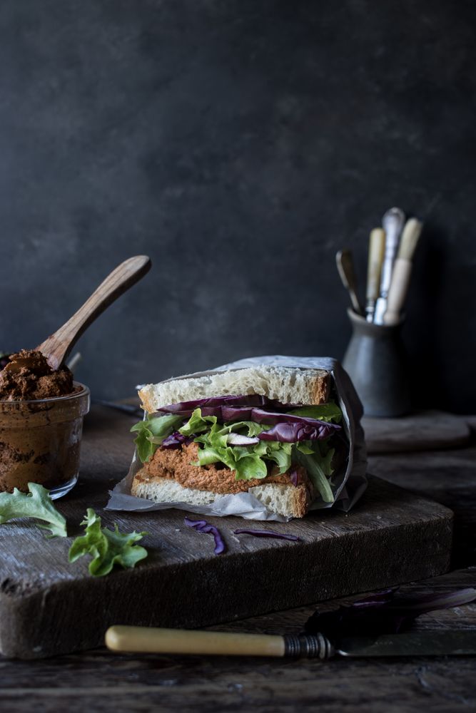 Sandwich with vegetables and dry tomatoes pate on tray