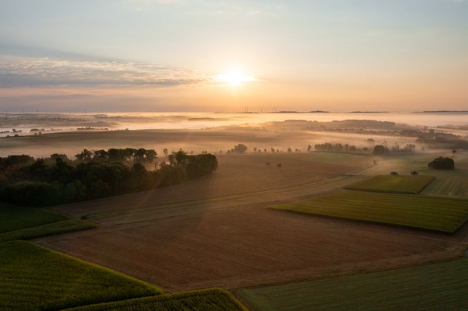 Drone image at sunrise with rolling landscapes covered in fog