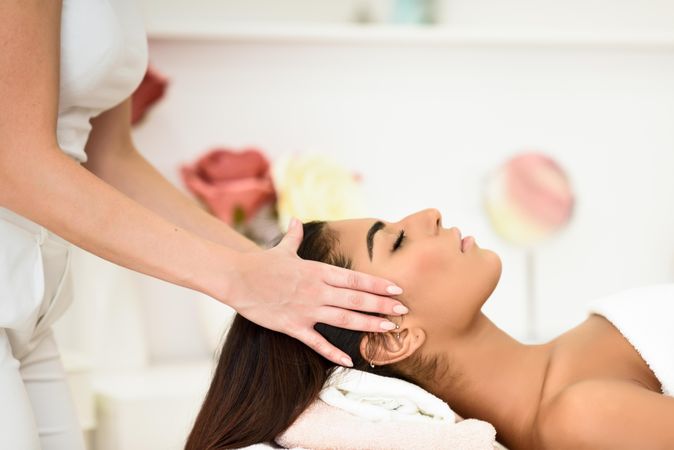 Female having her temples massaged in spa wellness center