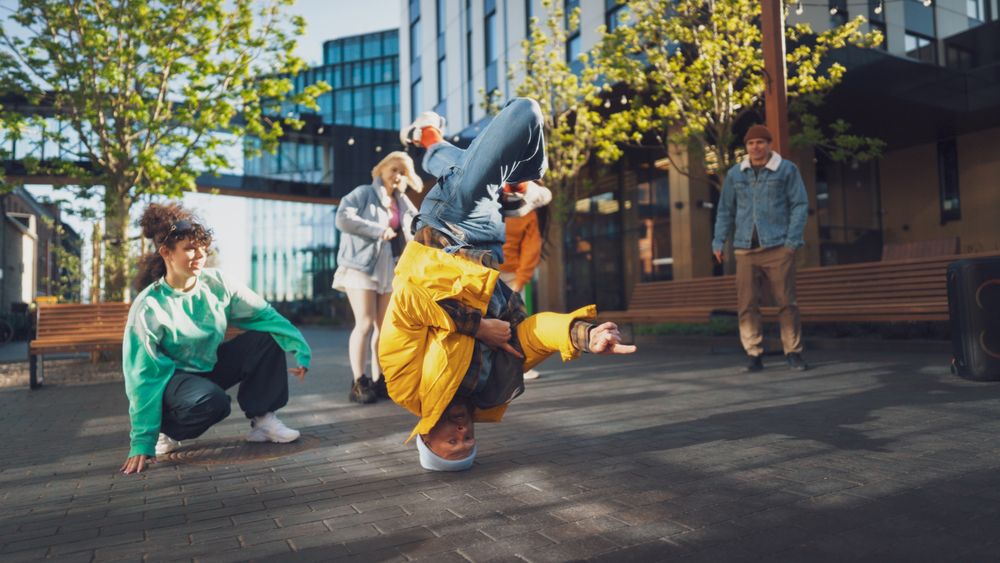 Vibrant Outdoor Scene Capturing A Diverse Group Of Young Adults Energetically Dancing