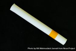 Cigarette laying diagnolly on dark background 0WOP2r