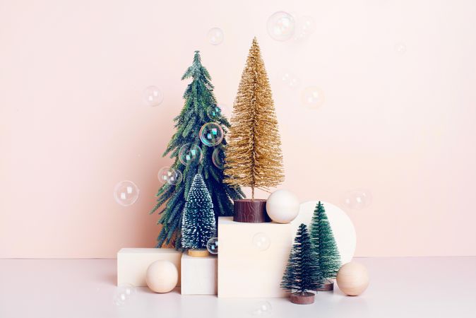 Festive still life with cute fake Christmas trees and bubbles