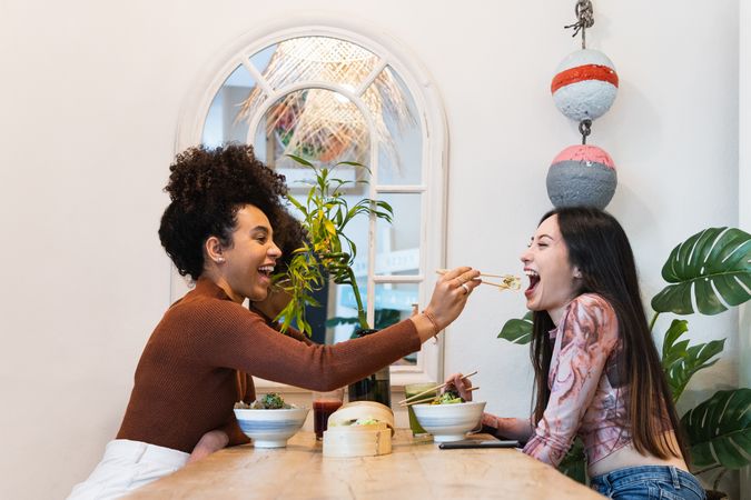 Friendly diverse women eating in restaurant together