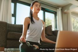 Chinese woman practicing yoga with laptop at home. 5RKyR4