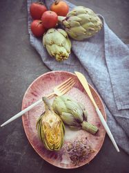 Delicious artichokes near ripe tomatoes