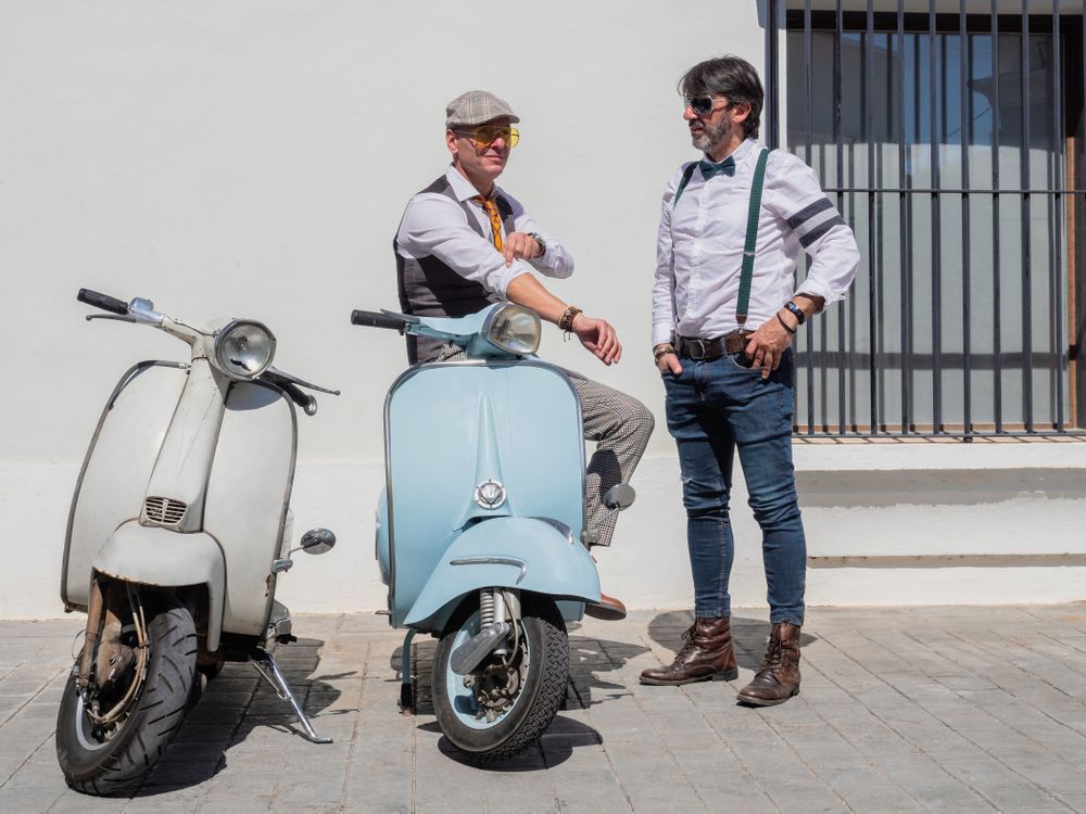 Trendy men sitting on vintage scooters