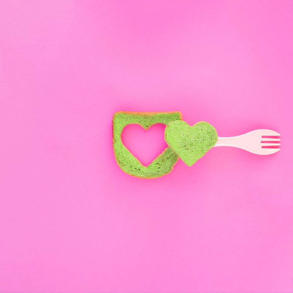 Green bread with heart piece cut in the center and plastic fork