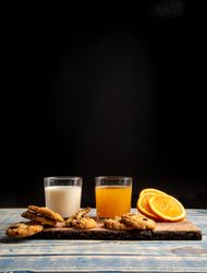 Glasses near fruits and cookies on table near napkin