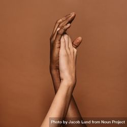 Close up of two female hands together on brown background bYPnj4