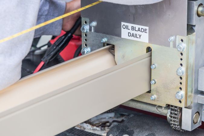 Worker Measuring Rain Gutter Processing Through Seamless Shaping Machine