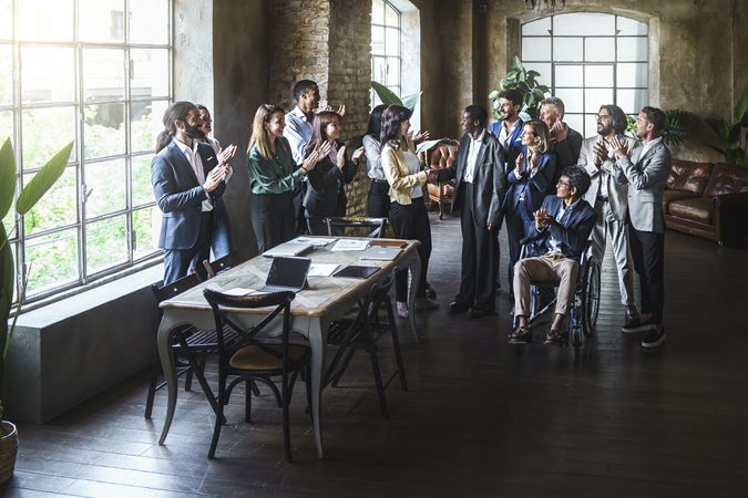 Group of colleagues applauding in office