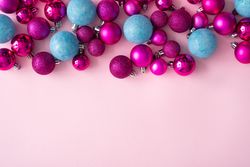 Pink and blue festive baubles on side of pink background