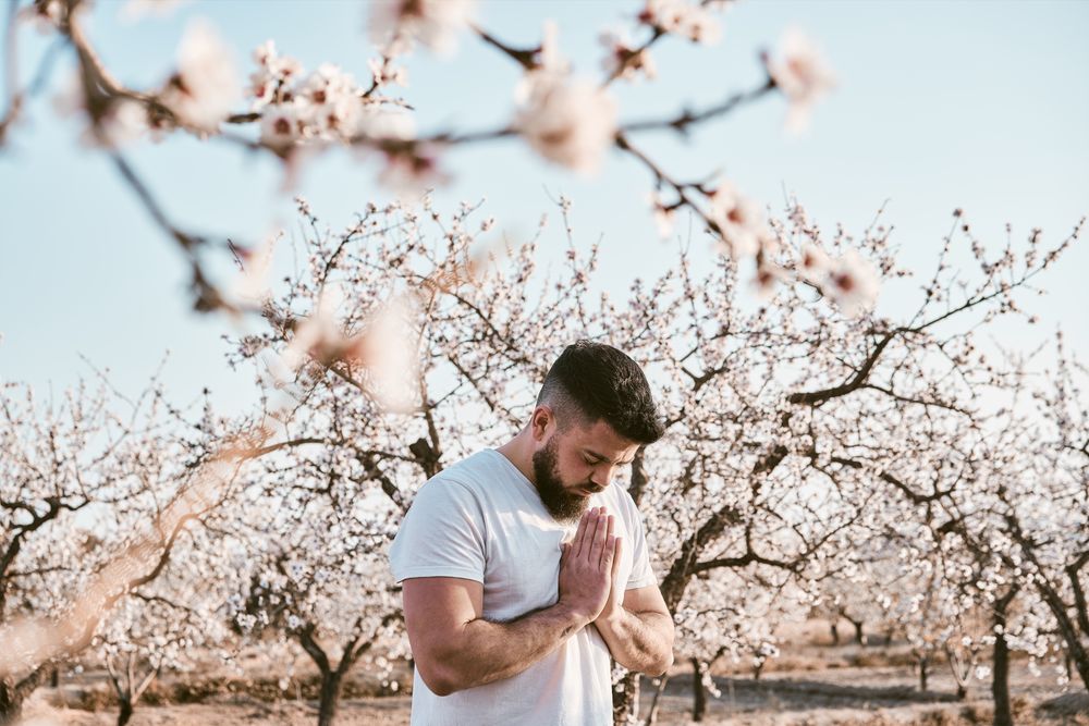 Bearded man meditating in spring garden