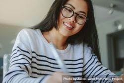 Smiling young woman wearing eyeglasses studying at home 5a7ZGb