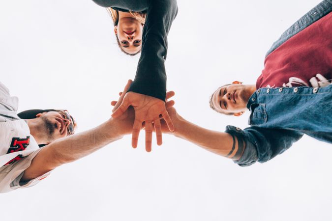 Group of young people putting hands together