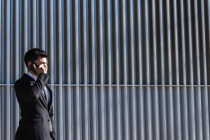 Smiling businessman speaking on smartphone in downtown