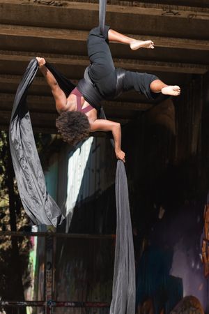 woman doing aerial yoga in city