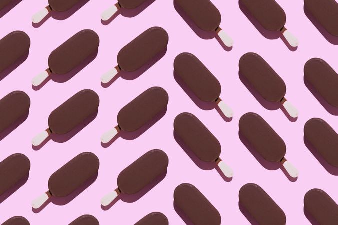 Chocolate popsicles on pink background