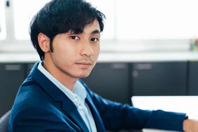 Asian male in suit in his work office