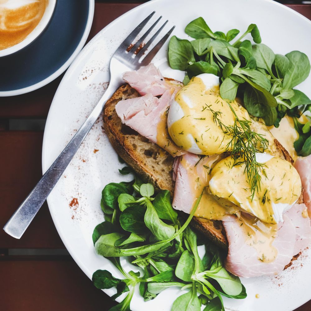 Eggs Benedict with greens, top view, square crop