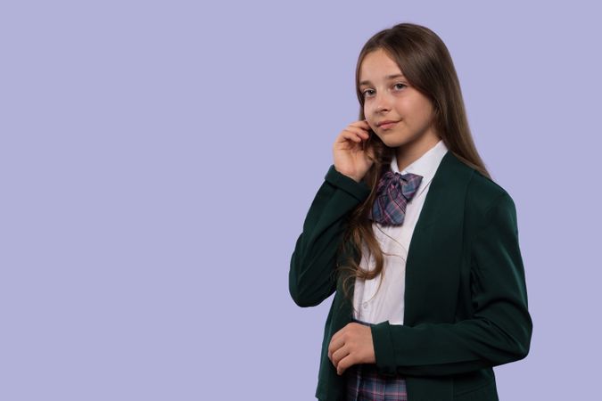 Girl in green blazer gently touching face