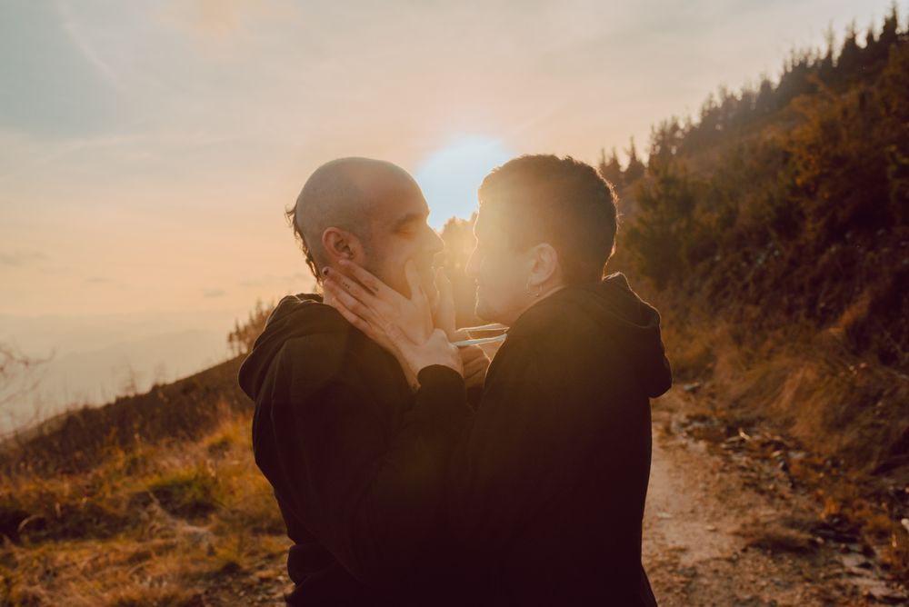 Men hugging and kissing in forest