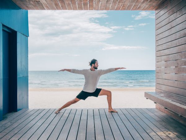Man doing yoga by the beach