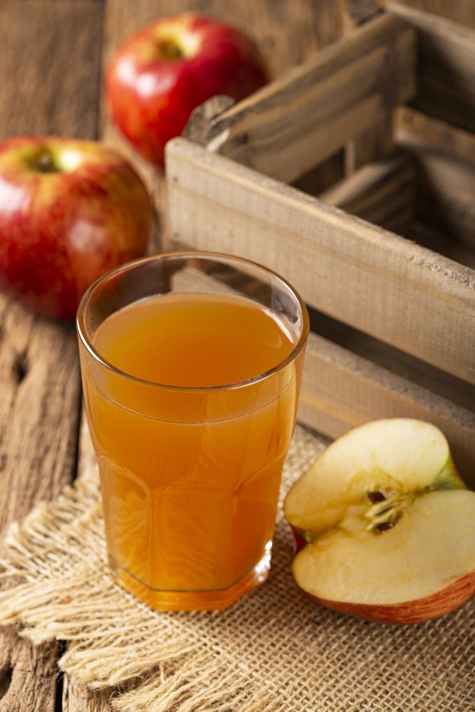 Apple juice and red apples on the table.