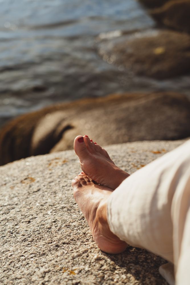 Person relaxing while sitting on stone