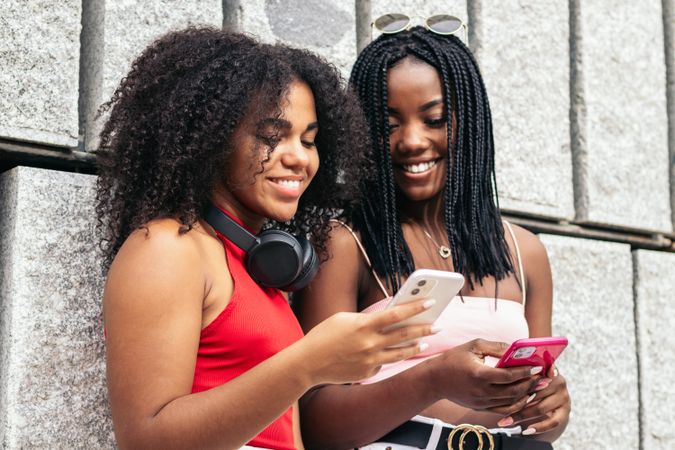 Black Female Friends Enjoying Summer Together and using smartphone