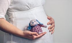 Pregnant holding a baby rag doll