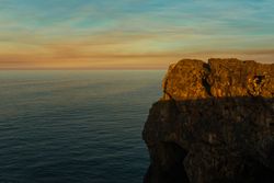 Majestic cliffs of ocean coastline in sunset
