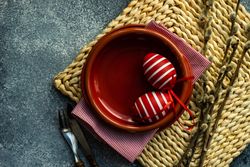 Easter holiday table setting with elegant red egg decorations in red bowl