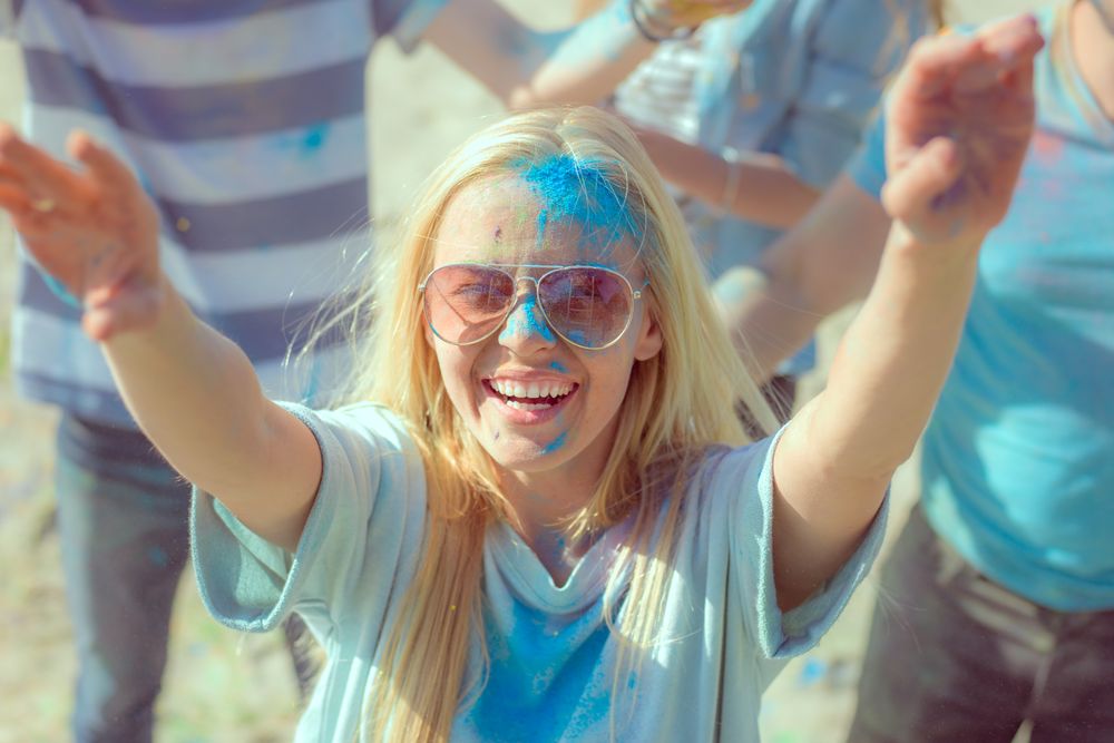 Woman Throwing Colorful Powder in the Crowd Amidst Hindu Holi Festival Celebrations.