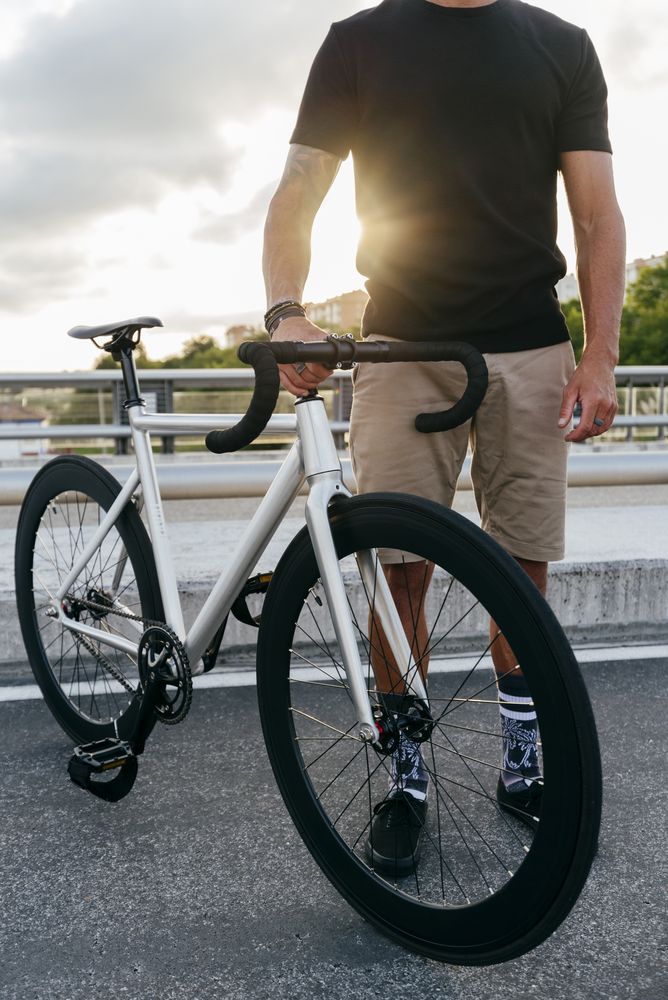 Man with bike standing on bridge