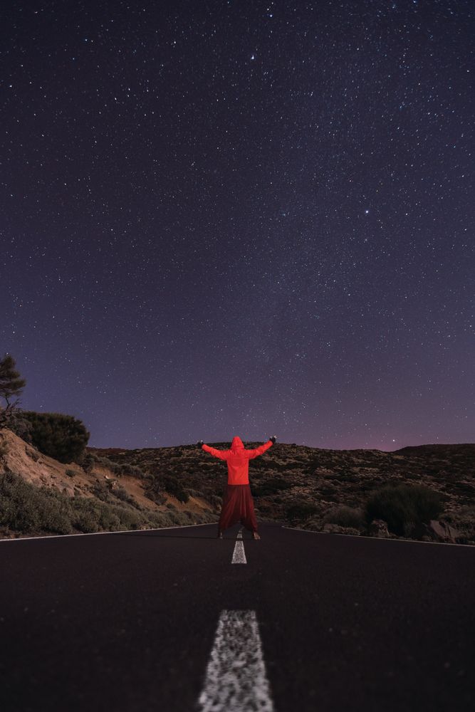 Traveler standing on empty road at night