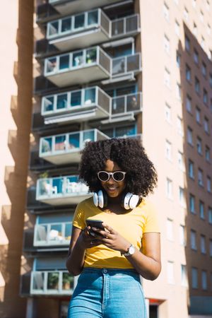 Black woman listening to music with headphones.