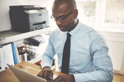 Man working from home office in shirt and tie