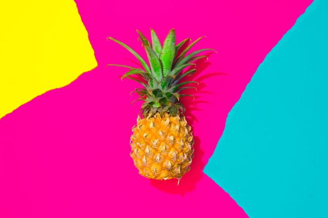 Pineapple on pattern of ripped paper in vivid colors